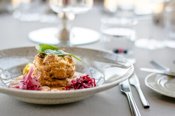 Pike cutlet with pumpkin sauce and fermented cabbage in different colors at a restaurant