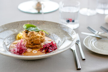 Pike cutlet with pumpkin sauce and fermented cabbage in different colors at a restaurant