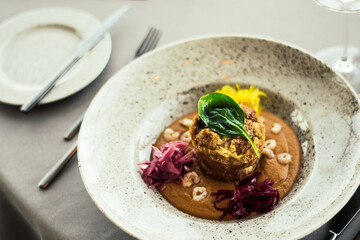 Pike cutlet with pumpkin sauce and fermented cabbage in different colors at a restaurant