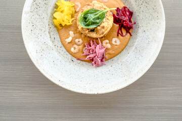 Pike cutlet with pumpkin sauce and fermented cabbage in different colors at a restaurant