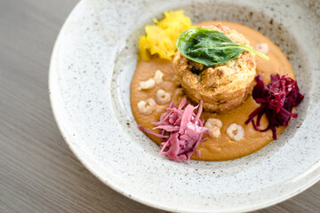 Pike cutlet with pumpkin sauce and fermented cabbage in different colors at a restaurant
