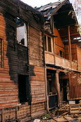 Old wooden two-storey house without windows after a fire