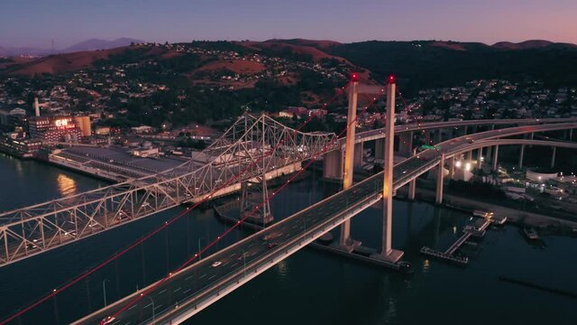 Aerial: Freeway traffic on the Alfred Zampa Memorial Bridge and Carquinez Bridge at night between Oakland and Vallejo. California, USA
