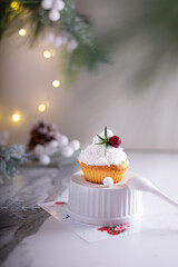 Christmas cupcakes with vanilla frosting, cranberries and rosemary on white background. Vertical