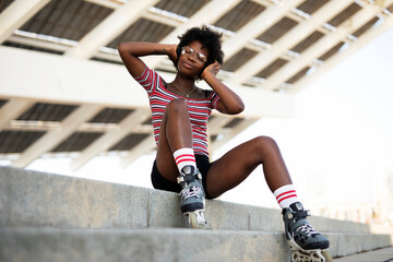 Beautiful African woman with roller skates. Urban sexy girl having fun outside..