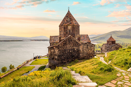 View of the symbol of tourist Armenia - Sevanavank Monastery on the peninsula overlooking Lake Sevan in sunny weather.