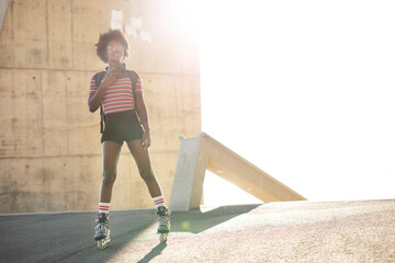 Beautiful African woman with roller skates. Urban sexy girl having fun outside..