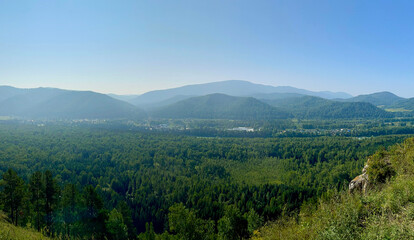 Dense forest in the valley, against the backdrop of mountains