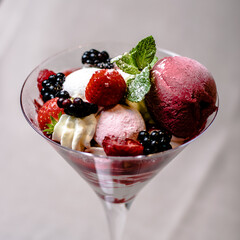 Ice cream serving in a glassware with different berries