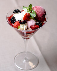 Ice cream serving in a glassware with different berries