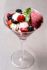 Ice cream serving in a glassware with different berries