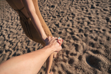 Asian couple holding hands walking on the beach in summer