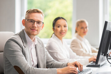 Diverse team of young professionals is working in the e-mail support center. Working day of sales managers in office. Business, consulting, and problem solving via email.