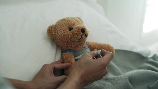 Using a bear as a child representation. man used a digital thermometer to measure his body temperature and found had a high fever.
