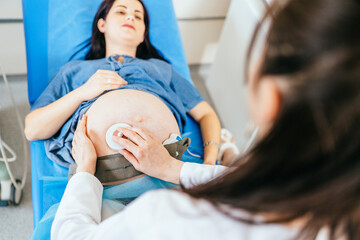 Doctor monitoring baby heartbeat of pregnant woman