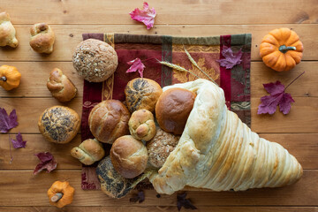 A cornucopia made of bread filled with a variety of rolls. A Thanksgiving concept.