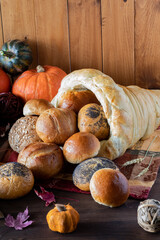 Vertical view of buns pouring out of a bread cornucopia. A Thanksgiving concept.