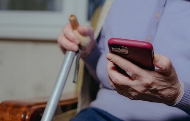 Mobile phone. An old grandmother is talking on a modern mobile phone.