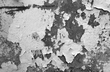 Сement wall with peeling paint and plaster in black and white.