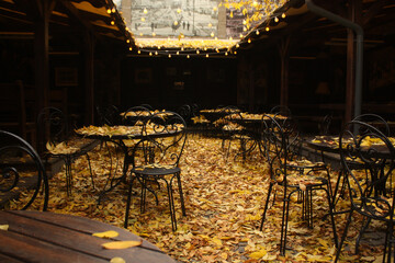Open cafe yard with table full of fallen leaves.