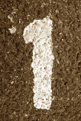 Number one on asphalt in brown tone.