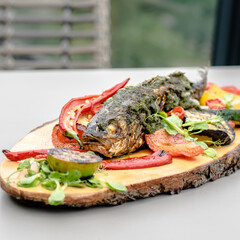 Fried fish on a wood plate at a restaurant