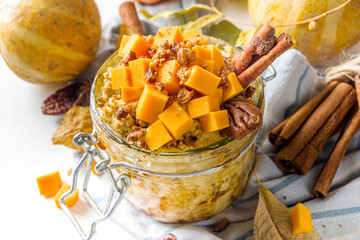 Autumn pumpkin pecan oatmeal, overnight oats porridge with butternut squash slices, pecan nuts and...