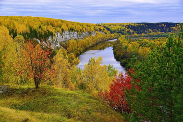 Obraz premium A rock outcrop of the gypsum mountain Podkamennaya overhangs the Sylva River in the Kungur region