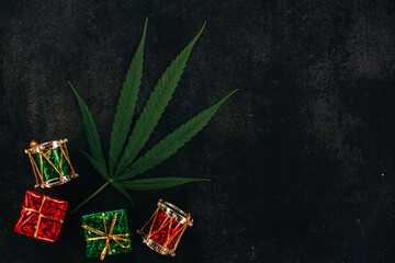 Christmas background, Christmas decor. Pattern of hemp leaves, cannabis and Christmas decorations on a dark background.