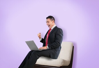 Man using a laptop against color background