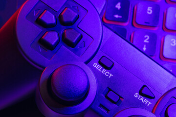 Accessory gaming keyboard joystick mouse headphone with blank space. Gadget for gamer playing video game online in the neon light darkroom. © Chanakon