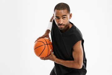 Young black sportsman playing basketball while working out