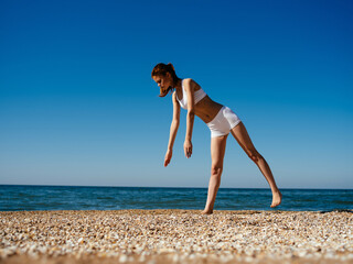 woman in swimsuit meditates ocean landscape