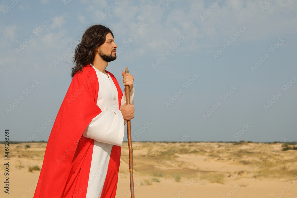 Wall mural jesus christ walking with stick in desert. space for text