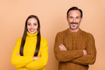 Photo of ceo brunette couple crossed arms wear fall knitwear sweater isolated on beige color...