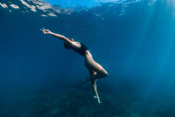 Woman freediver posing underwater in ocean. Free diving and beautiful lady