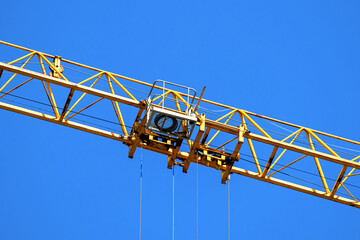 Yellow construction crane operating, blue sky background photo