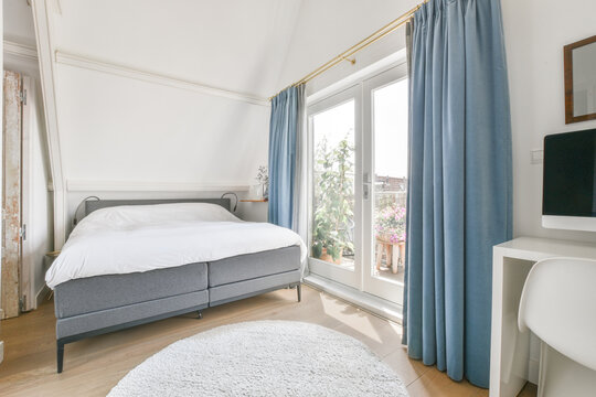 Light bedroom interior with comfy bed placed near window