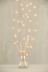 Aromatic reed air freshener on light table against blurred lights
