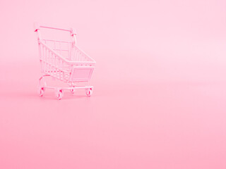 shopping and payment concept from small trolley on pink pastel color background.