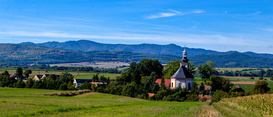 Fototapeta na wymiar A Polish village near the mountains with a church