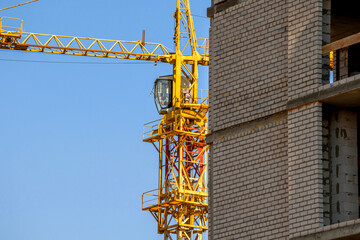 Construction site and yellow crane on the background blue sky