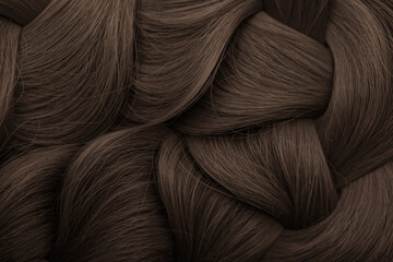 Brunette or brown hair. Female long dark hair in black. Beautifully laid curls. Closeup texture in a dark key. Hairdressing, hair care and coloring. Shading gray hair. Background with copy space.