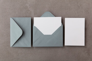 Blank white card with grey paper envelope template mock up on a concrete background - obrazy, fototapety, plakaty