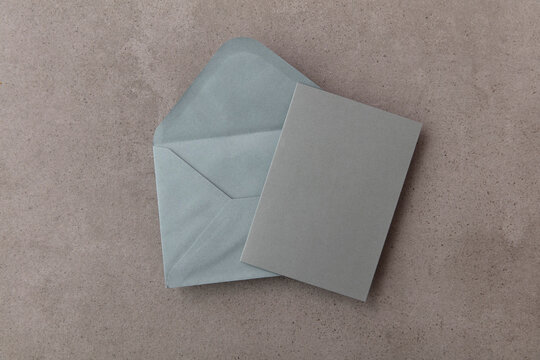 Blank Grey Card With Grey Paper Envelope Template Mock Up On A Concrete Background