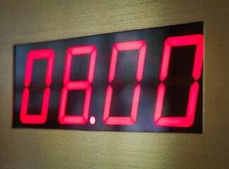 Digital clock face shows 8 o'clock in the morning or evening.