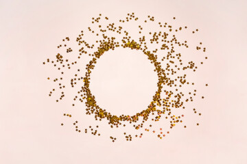 Obraz premium Wreath of golden stars on pink. Stardust border background. Magic christmas frame. Holiday concept