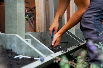 The making of a vertical green wall garden from recycled waste plastics, with substrate and an irrigation system with valves