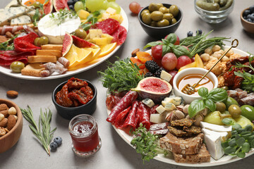 Set of different delicious appetizers served on light grey table