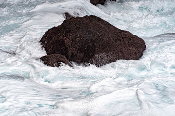 sea in tempest breaking waves on lava rock cliff - obrazy, fototapety, plakaty
